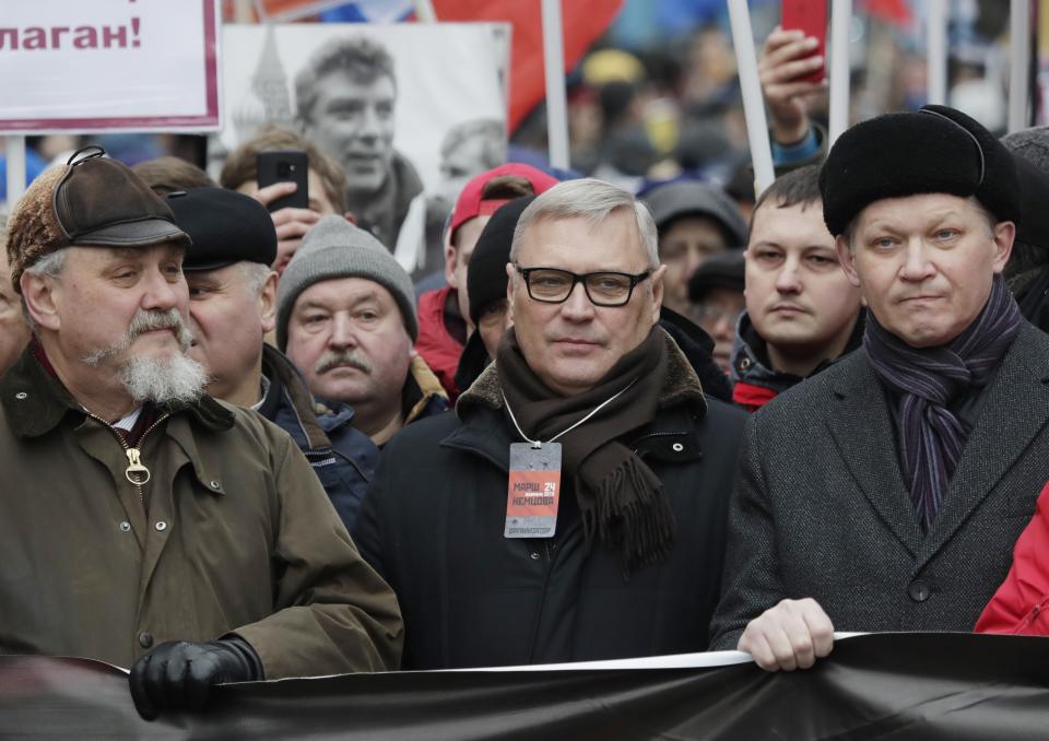 Former Russian Prime Minister, and one of opposition leaders, Mikhail Kasyanov, center, attends a march in memory of opposition leader Boris Nemtsov in Moscow, Russia, Sunday, Feb. 24, 2019. Thousands of Russians took to the streets of downtown Moscow to mark four years since Nemtsov was gunned down outside the Kremlin. (AP Photo/Pavel Golovkin)