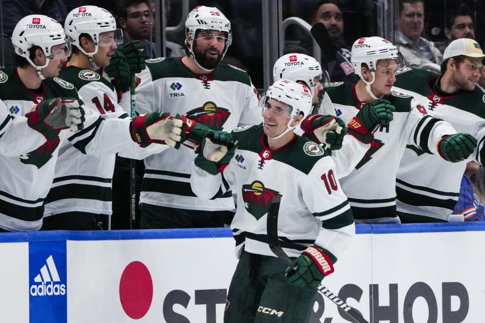 Minnesota Wild's Vinni Lettieri (10) celebrates with teammates after scoring a goal during the second period of an NHL hockey game against the New York Islanders Tuesday, Nov. 7, 2023, in Elmont, N.Y. (AP Photo/Frank Franklin II)