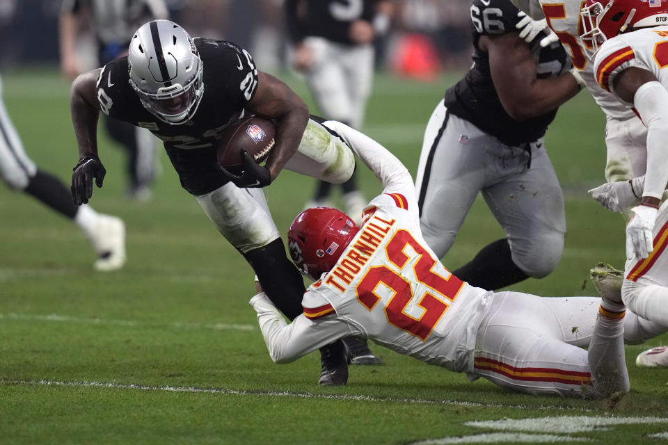 Las Vegas Raiders running back Josh Jacobs (28) as Kansas City Chiefs safety Juan Thornhill (22) defends during the second half of an NFL football game Saturday, Jan. 7, 2023, in Las Vegas. (AP Photo/John Locher)