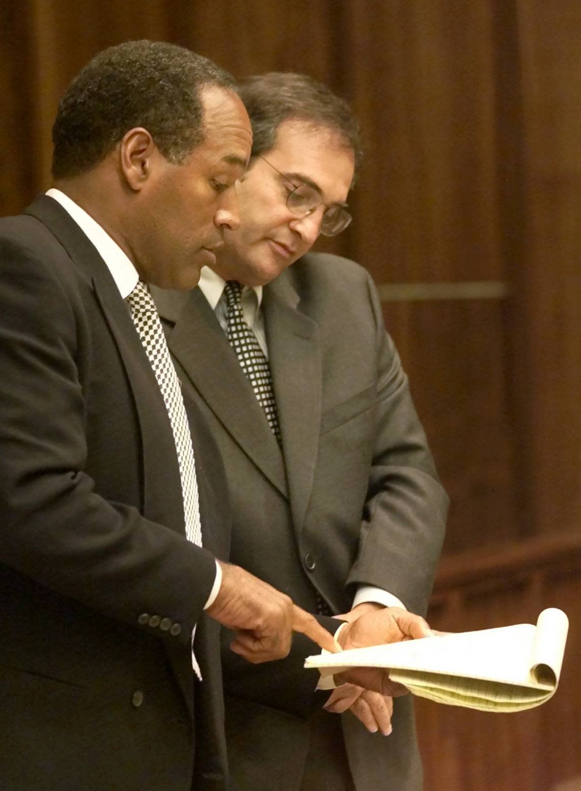 O.J. Simpson, left, talks with his attorney Lee Cohn, in Miami-Dade Circuit Court, Friday, Oct. 12, 2001, during the fourth day of jury selection for Simpson’s trial on auto burglary and battery charges. POOL PHOTO/AP