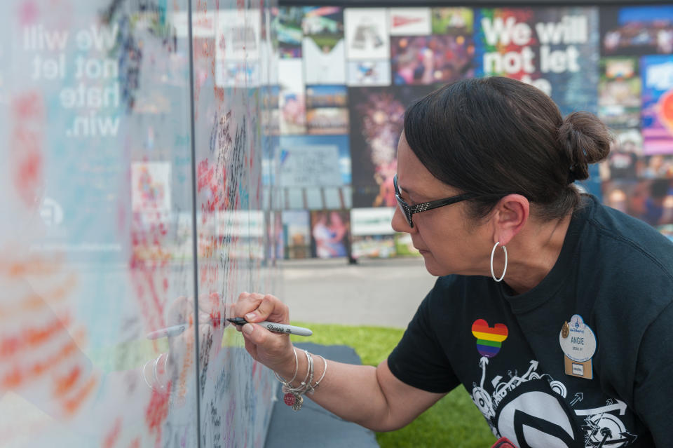 Angie Sola, volunteer working with Disney, leaves a message on the Pulse sign at the interim Pulse nightclub memorial in Orlando, Florida on June 4, 2018.