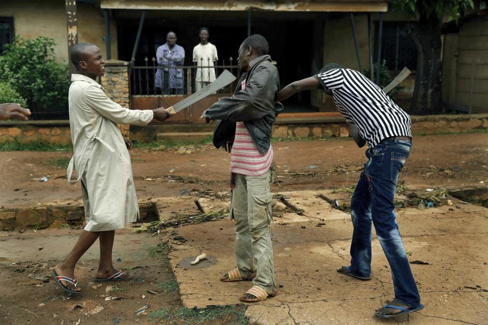 FILE - In this Friday, Dec. 13, 2013 file photo, Muslim men organized in militias with machetes beat a Christian man while checking him for weapons in the Miskine neighbourhood of Bangui, Central African Republic. Central African Republic and 14 rebel groups signed a peace deal on Wednesday, Feb. 6, 2019 even as some expressed alarm about the possible suspension of prosecutions after five years of bloody conflict. (AP Photo/Jerome Delay, File)