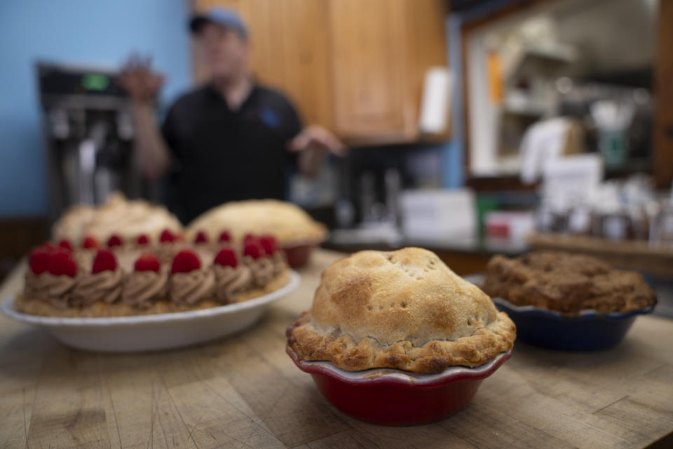 Manager Stephen Jarrett prepares pies on a counter at Michele's Pies, Wednesday, March 13, 2024, in Norwalk, Conn. Math enthusiasts and bakers celebrate Pi Day on March 14 or 3/14, the first three digits of a mathematical constant with many practical uses. Around the world many people will mark the day with a slice of sweet or savory pie. (AP Photo/John Minchillo)