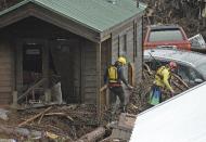 Rescue crews search for victims Friday, Jan. 20, 2017 at the El Capitan Canyon campground following flooding due to heavy rains in Gaviota, Calif. Dozens of campers were rescued and evacuated following the morning flood that swept large wooden cabins and vehicles away. (Mike Eliason/Santa Barbara County Fire Department via AP)