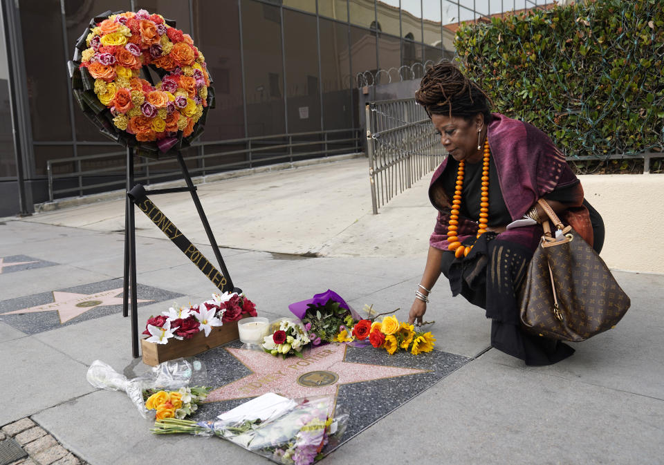 Marie Deary of Long Beach, Calif. lays down flowers at the late actor Sidney Poitier's star on the Hollywood Walk of Fame, Friday, Jan. 7, 2022, in Los Angeles. Poitier, the first Black actor to win an Academy Award for best lead performance and the first to be a top box-office draw, died Thursday at 94. (AP Photo/Chris Pizzello)