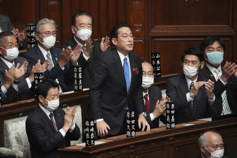 Fumio Kishida, center, is applauded after being elected as Japan's prime minister at the parliament's lower house Monday, Oct. 4, 2021, in Tokyo. Kishida was formally elected Monday as Japan's new prime minister in a parliamentary vote, replacing Yoshihide Suga. (AP Photo/Eugene Hoshiko)