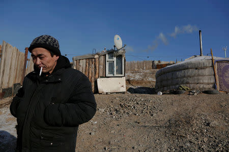 Setevdorj Myagmartsogt smokes a cigarette outside his tent-like ger home, which is heated by coal burning stove, in Ulaanbaatar, Mongolia January 29, 2017. Setevdorj Myagmartsogt lives with his wife, four children and two relatives in his ger near a coal depot not far from the centre of the Mongolian capital. REUTERS/B. Rentsendorj