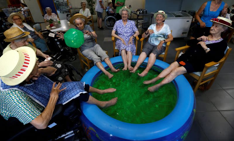 Residents at the Ter Biest house for elderly persons refresh their feet in a pool as a heat wave hits Europe, in Grimbergen