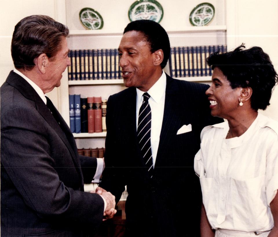 President Ronald Reagan shakes hands with Wayne County Executive William Lucas, center, as his wife Evelyn looks on at right during a meeting in the Oval Office at the White House Sept. 8, 1986.