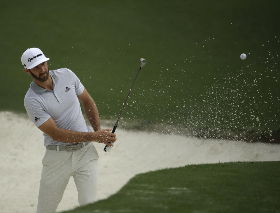 FILE - In this Wednesday, April 5, 2017, file photo, Dustin Johnson hits from a bunker on the 10th hole during a practice round for the Masters golf tournament, in Augusta, Ga. The world's No. 1-ranked player was forced to withdraw from the Masters on Thursday because of a lower back injury suffered less than 24 hours earlier in a freak fall at the home he was renting for the week. (AP Photo/Charlie Riedel, File)