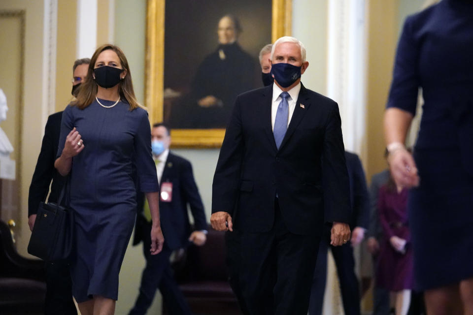 Judge Amy Coney Barrett, President Donald Trump's nominee for the U.S. Supreme Court, is escorted to the Senate by Vice President Mike Pence where she will begin a series of meetings to prepare for her confirmation hearing, at the Capitol in Washington, Tuesday, Sept. 29, 2020. (AP Photo/J. Scott Applewhite)