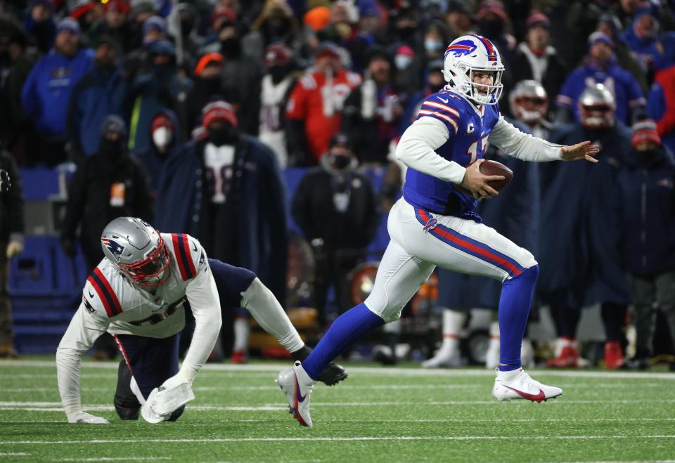 Bills Quarterback Josh Allen escapes a tackle by Patriots Christian Barmore. 