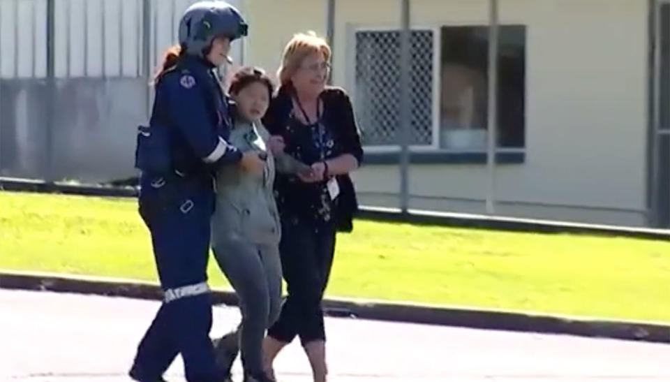 Rescuers help Joohee Han walk after she was winched to safety following nearly a week in Queensland bushland. Source: 7 News