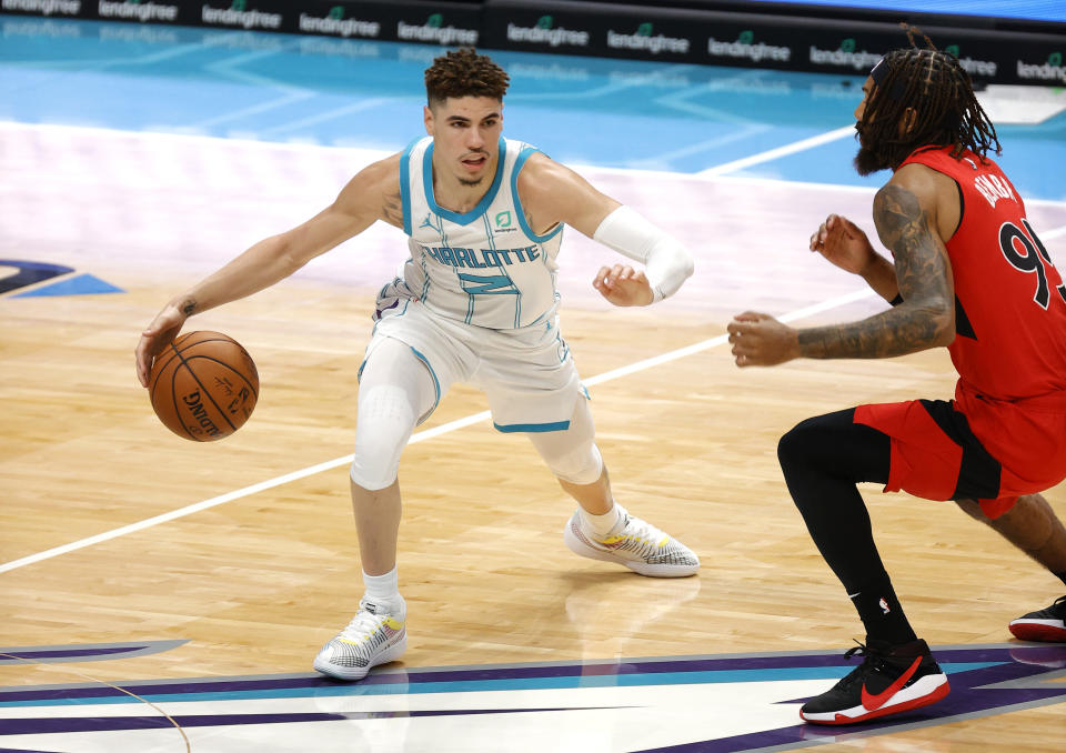 CHARLOTTE, NORTH CAROLINA - DECEMBER 12: LaMelo Ball #2 of the Charlotte Hornets dribbles against DeAndre' Bembry #95 of the Toronto Raptors during the second half of their game against the Toronto Raptors at Spectrum Center on December 12, 2020 in Charlotte, North Carolina. (Photo by Jared C. Tilton/Getty Images)