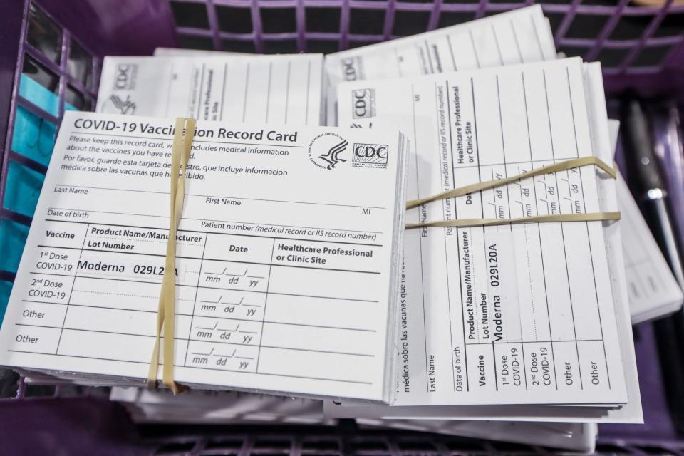 A stack of vaccine cards wait to be handed out to registered residents after they receive their Moderna COVID-19 vaccines from the Oakland County Health Division at Suburban Showplace in Novi, Mich. on Jan. 23, 2021. Three thousand four hundred appointments were made for groups 1A and 1B based on the State of Michigan's COVID-19 Vaccination plan