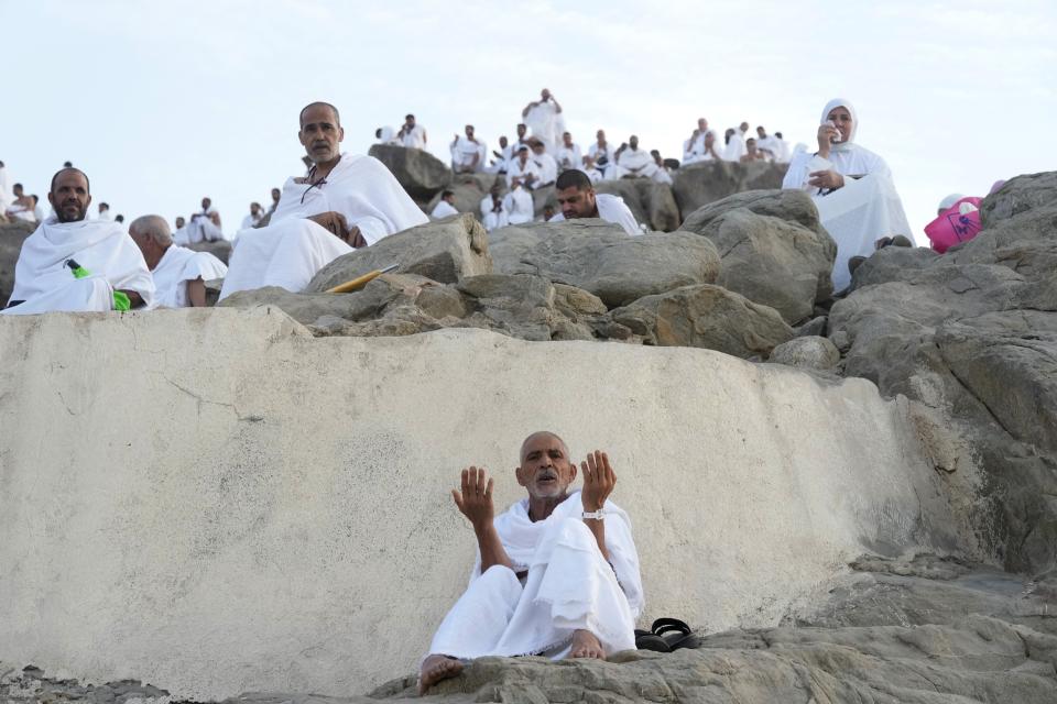 Muslim pilgrims pray on top of the rocky hill known as the Mountain of Mercy, on the Plain of Arafat, during the annual hajj pilgrimage, near the holy city of Mecca, Saudi Arabia, Friday, July 8, 2022. (AP Photo/Amr Nabil)