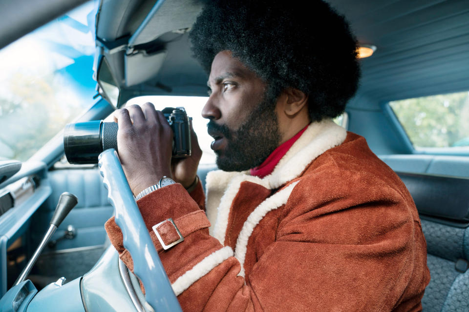 John David Washington in a car taking photos as Stallworth