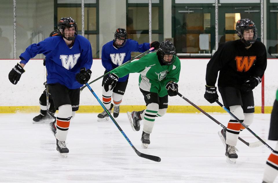 Wayland High sophomore Sam Brande (center) skates through drills at the start of the boys hockey team's practice, Jan. 14, 2022.