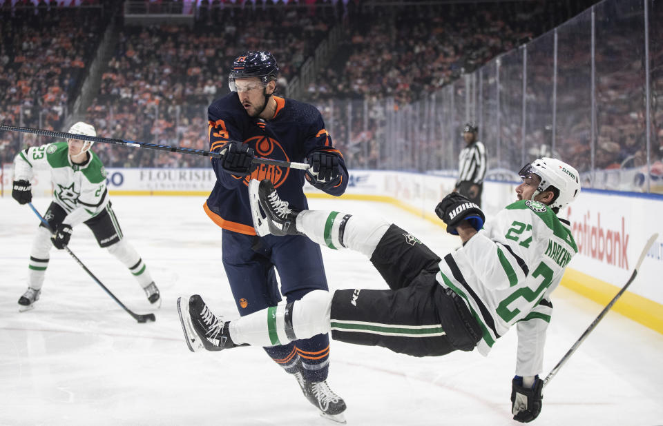 Dallas Stars' Mason Marchment (27) is checked by Edmonton Oilers' Vincent Desharnais (73) during the first period of an NHL hockey game Thursday, Nov. 2, 2023, in Edmonton, Alberta. (Jason Franson/The Canadian Press via AP)