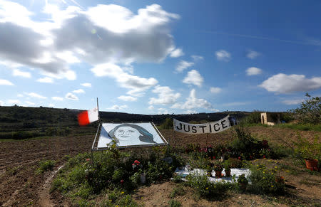 A portrait of anti-corruption investigative journalist Daphne Caruana Galizia is seen on the site of her murder in the run-up to activities marking one year since her assassination in a car bomb, in Bidnija, Malta October 15, 2018. REUTERS/Darrin Zammit Lupi