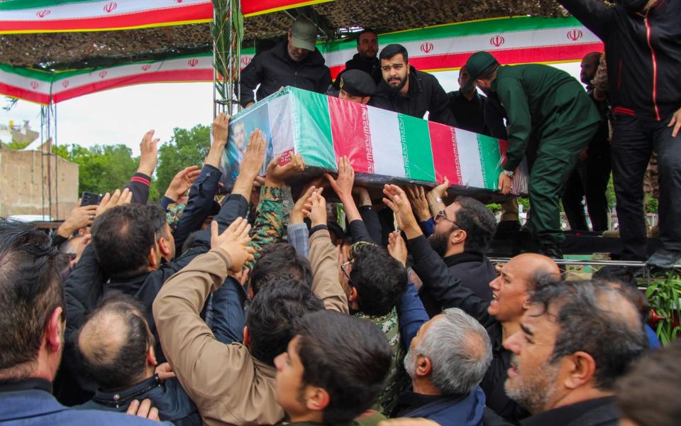 People help to lift a coffin onto the truck at the beginning of the funeral procession.