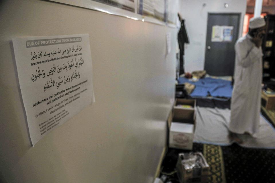 In this Wednesday, April 22, 2020, photo, a prayer of "protection from diseases" is printed in Arabic and English on a paper posted to the wall of the An-Noor Cultural Center and masjid, which serves a mostly Bangladeshi Muslim community in the Elmhurst neighborhood in the Queens borough of New York. "Close to 150 people we lost in this COVID19 crisis," said Ismail, citing the death toll from the coronavirus outbreak on the Bangladeshi community, some who frequented the center only a few blocks from Elmhurst Hospital—the city's deadliest hospital for stricken patients. (AP Photo/Bebeto Matthews)