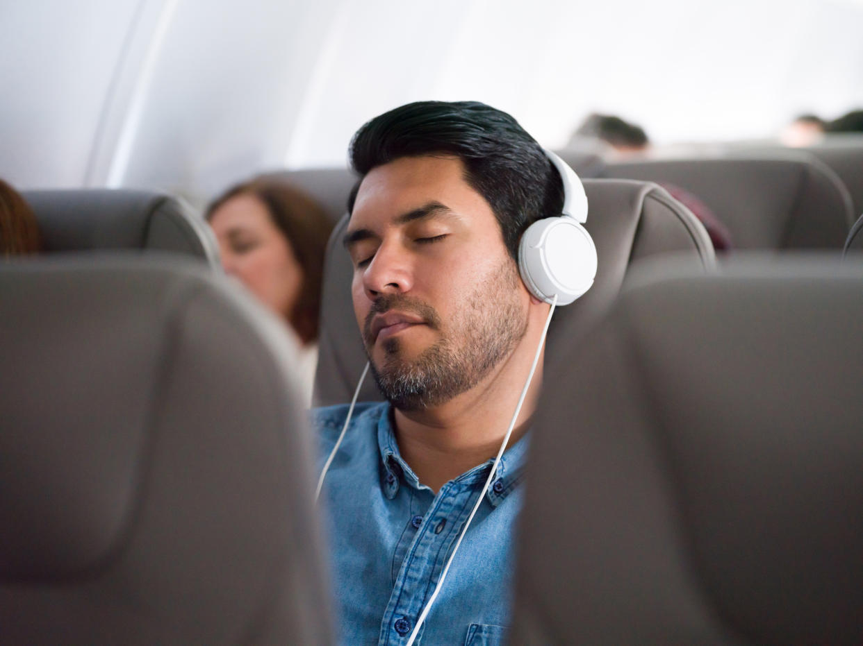 Noise-canceling headphones and other sleep cue objects could help you get some rest on your next flight, experts say.