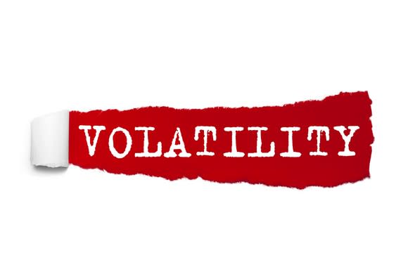 The word volatility written under the curled piece of red torn paper