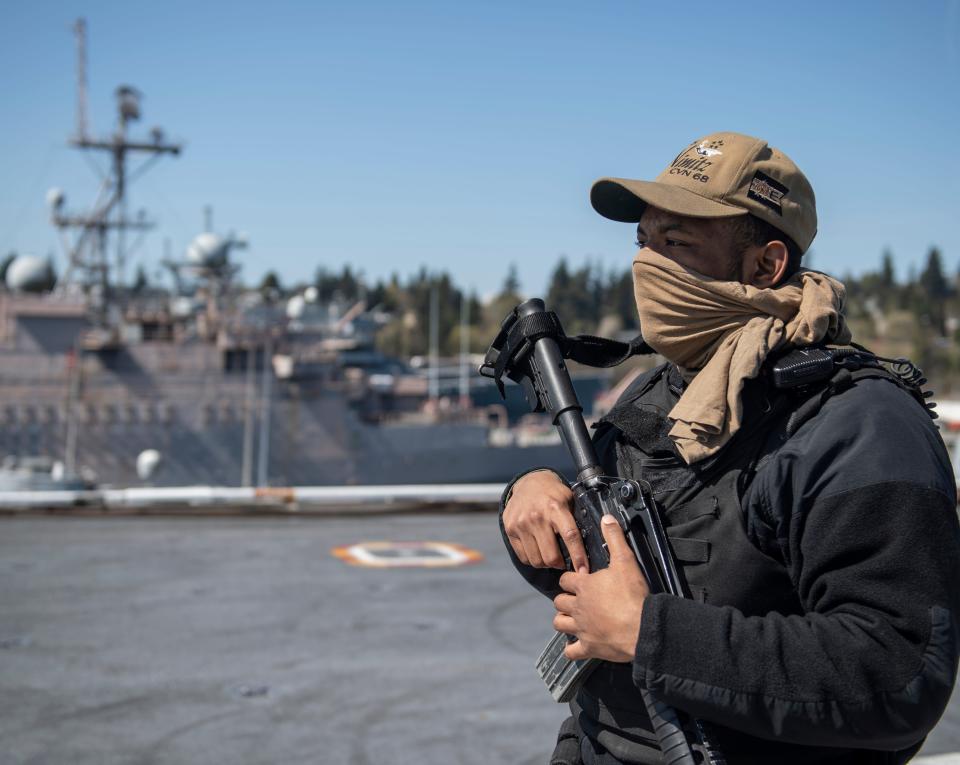 Airman Arlon Jones from Columbia, S.C., stands security watch on the flight deck aboard the aircraft carrier USS Nimitz while the carrier was in Bremerton.