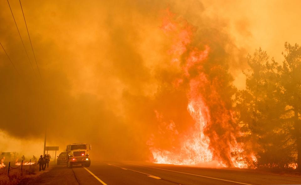 <p>Firefighters scramble to get control as flames from the Pawnee fire jump across highway 20 near Clearlake Oaks, Calif. on July 1, 2018. (Photo: Josh Edelson/AFP/Getty Images) </p>