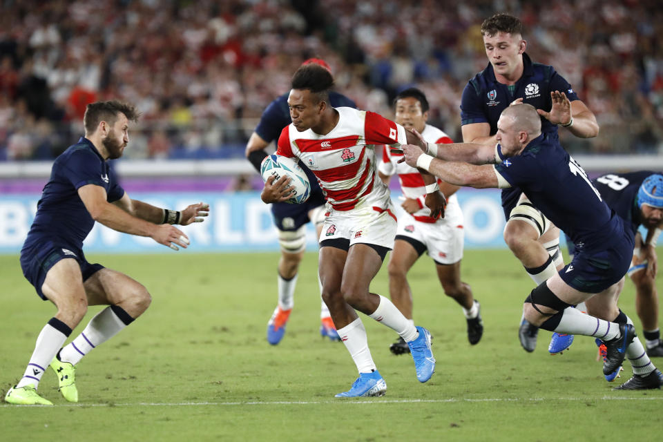 Japan's Kotaro Matsushima is chased by Scotland's Chris Harris, left, and Stuart Hogg, during the Rugby World Cup Pool A game at International Stadium between Japan and Scotland in Yokohama, Japan, Sunday, Oct. 13, 2019. (AP Photo/Eugene Hoshiko)