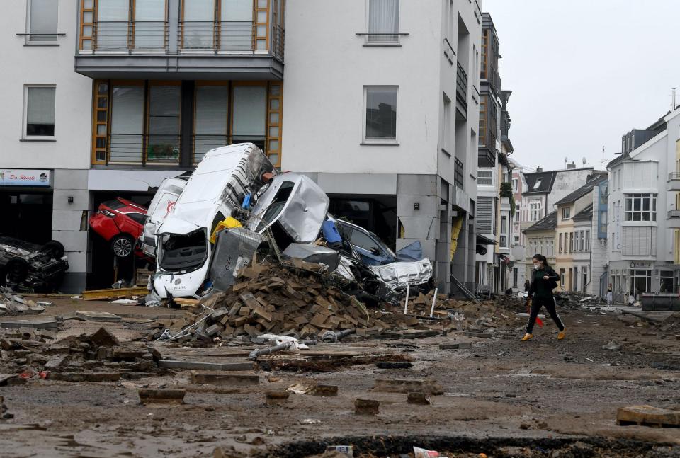 Multiple cars and rubble in front of a building