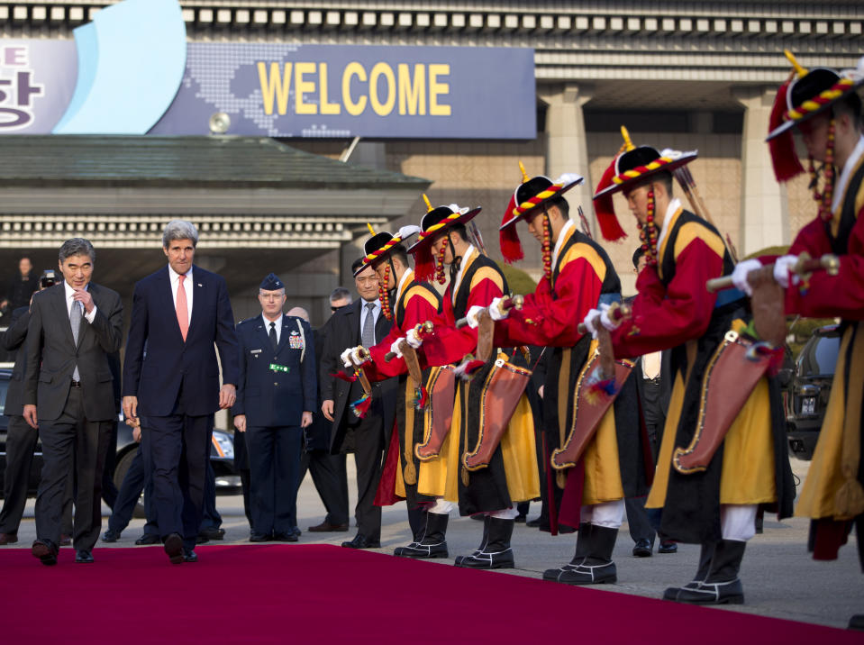 U.S. Secretary of State John Kerry, second left, walks to his plane to depart on a flight to Beijing on Friday, Feb. 14, 2014, in Seoul, South Korea. Kerry is visiting South Korea, China, Indonesia, and the United Arab Emirates on a seven-day trip. (AP Photo/Evan Vucci, Pool)