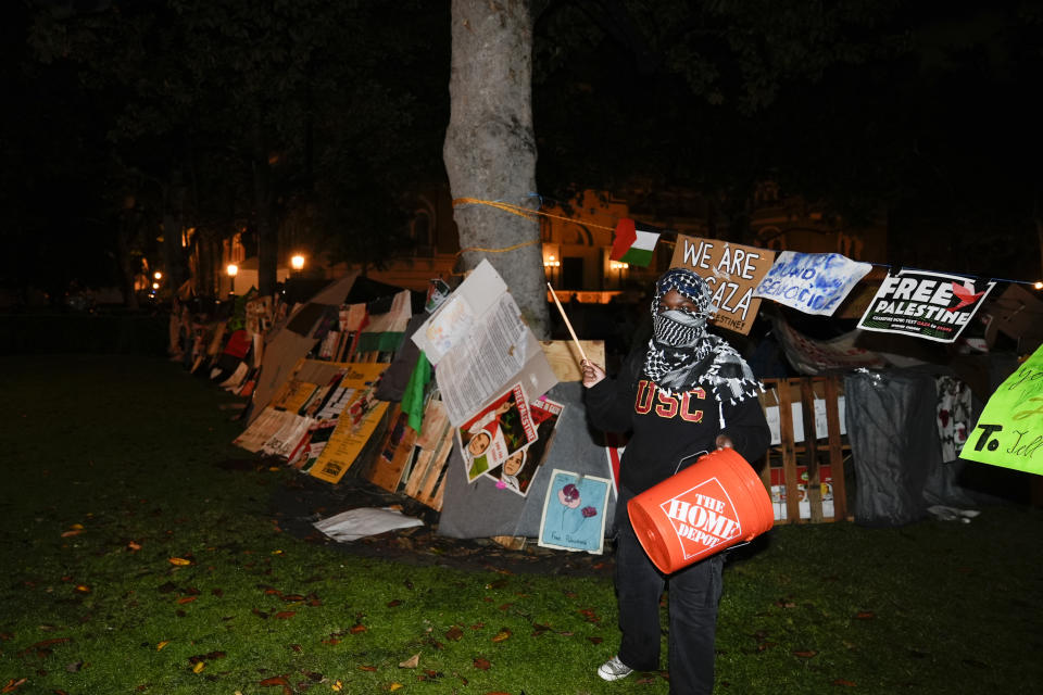 A demonstrator stands in front of an encampment set up by pro-Palestinian demonstrators on the campus at the University of Southern California after police arrived with orders to disperse Sunday, May 5, 2024, in Los Angeles. (AP Photo/Ryan Sun)