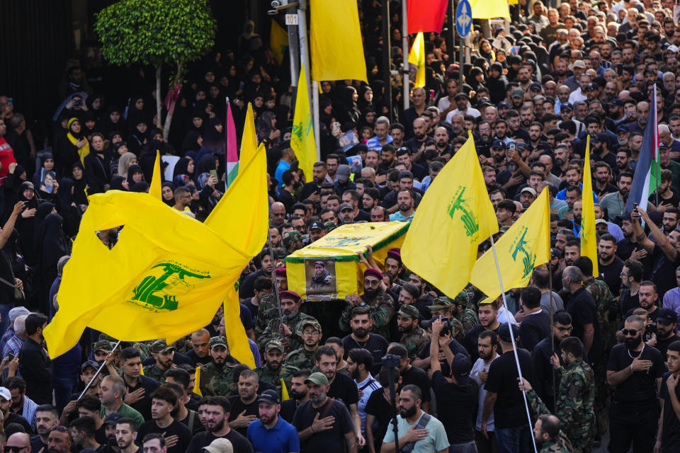 Hezbollah fighters carry the coffin of their comrade, Qassim Ibrahim Abu-Taam, who was killed along Lebanon's southern border with Israel, during his funeral procession in the southern Beirut suburb of Dahiyeh, Lebanon, Monday, Nov. 6, 2023. (AP Photo/Hassan Ammar)