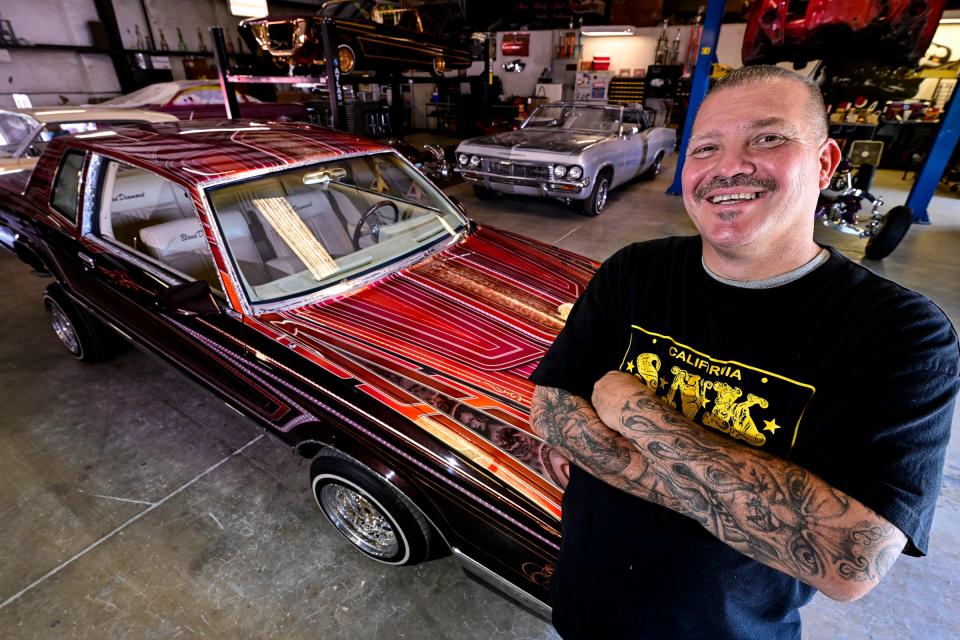 Steven Burk poses near a 1986 Chevy Monte Carlo with about 3,000 hours of work into it. Burk has been painting cars since he was 8-years-old and has been running his own custom shop, SNK Autobody & Hydraulics, for about 20 years.