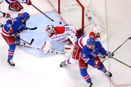 May 8, 2015; New York, NY, USA; Washington Capitals defenseman Matt Niskanen (2) clears the puck away after Washington Capitals goalie Braden Holtby (70) makes a save against New York Rangers center J.T. Miller (10) during the second period of game five of the second round of the 2015 Stanley Cup Playoffs at Madison Square Garden. Mandatory Credit: Brad Penner