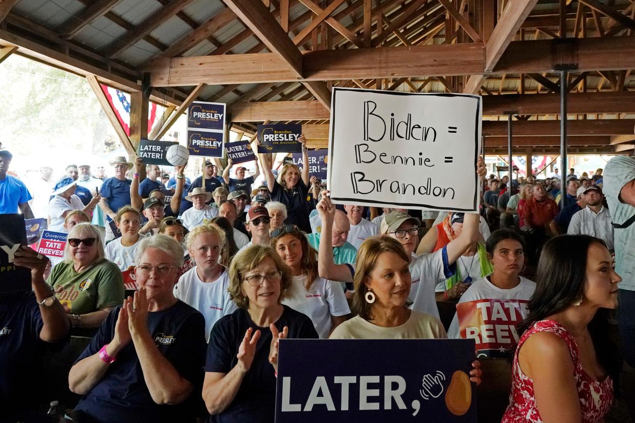 A person holds a sign that links President Joe Biden to Democratic U.S. Rep. Bennie Thompson of Mississippi and Brandon Presley, the Democratic nominee for Mississippi governor at the Neshoba County Fair near Philadelphia, Miss., on July 27, 2023. As Republican Gov. Tate Reeves seeks a second term, he faces Presley and independent candidate Gwendolyn Gray in the Nov. 7, 2023, general election. Reeves often says a vote for Presley equates to a vote for Biden and Thompson. (AP Photo/Rogelio V. Solis)