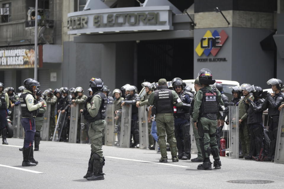 La policía y la Guardia Nacional se encuentran afuera del Consejo Nacional Electoral (CNE) el día después de las elecciones presidenciales en Caracas, Venezuela, el lunes 29 de julio de 2024. (AP Foto/Fernando Vergara)