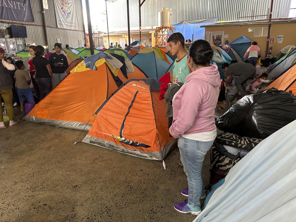 Teresa Muñoz, right, rests at a migrant shelter where she has been trying unsuccessfully for about a month to get an appointment to enter the United States through a new U.S. government mobile phone app in Tijuana, Mexico, Thursday, May 11, 2023. She fled her home in the Mexican state of Michoacan after her husband was killed and she was badly beaten. (AP Photo/Elliot Spagat)