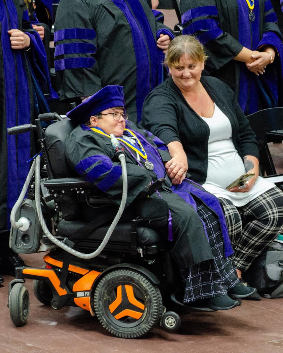 Jaclyn Sims, right, holds her daughter Megan Parker's hand during the University of Akron law school's commencement in May.