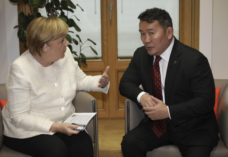 President of Mongolia Chaltmaagiin Battulga, right, meets with German Chancellor Angela Merkel on the sidelines of the ASEM 12 in Brussels, Thursday, Oct. 18, 2018. The informal meeting, which is held every two years, will discuss peace moves on the Korean Peninsula, migration, cybersecurity, fighting extremism and combating climate change. (AP Photo/Olivier Matthys, Pool)