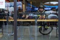 A delivery worker waits inside a Chick-fil-A restaurant on Thursday, Feb. 1, 2024, in New York. A wage law in New York City meant to protect food delivery workers is getting backlash from app companies like Uber, GrubHub and DoorDash, who have cut worker hours and made it more difficult to tip. (AP Photo/Peter K. Afriyie)