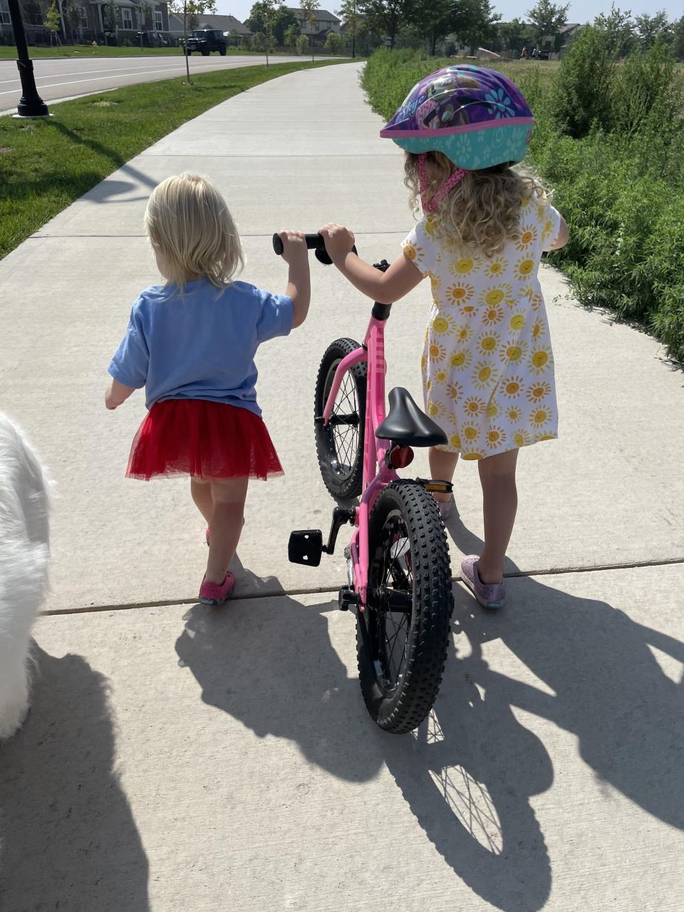 author's daughters pushing a bike