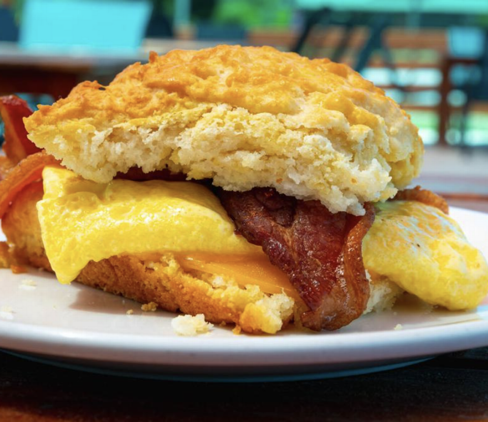 Maverick Biscuit features a breakfast sandwich with Tillamook sharp cheddar, scrambled egg and choice of fried chicken, bacon, ham, sausage or fried bologna.