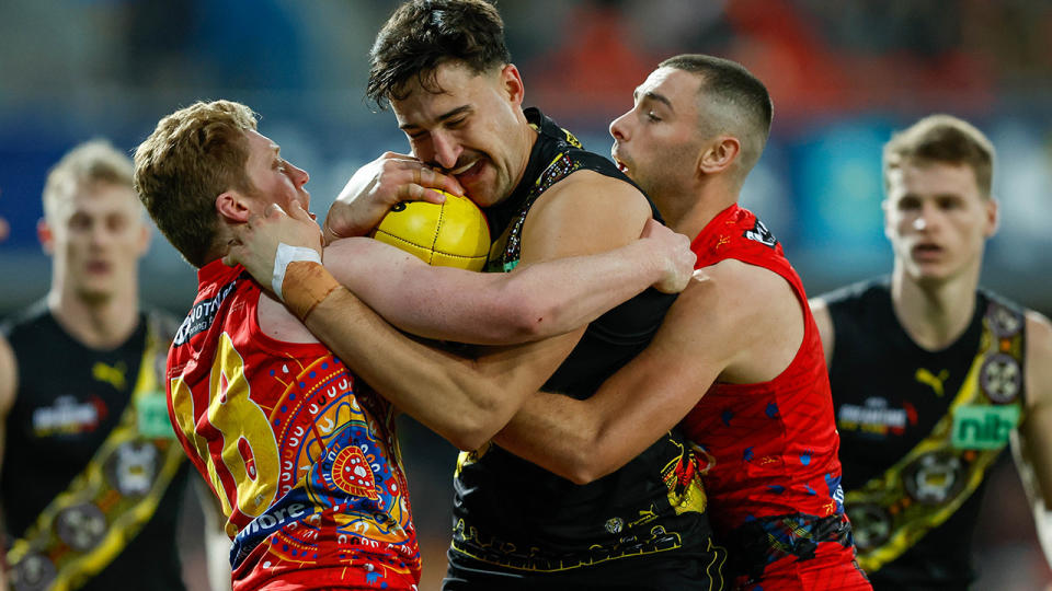 Richmond's Toby Nankervis is tackled by two Gold Coast Suns players.