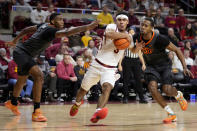 Iowa State guard Tamin Lipsey (3) drives to the basket between Oklahoma State center Brandon Garrison, left, and guard Bryce Thompson, right, during the second half of an NCAA college basketball game, Saturday, Jan. 13, 2024, in Ames, Iowa. (AP Photo/Charlie Neibergall)