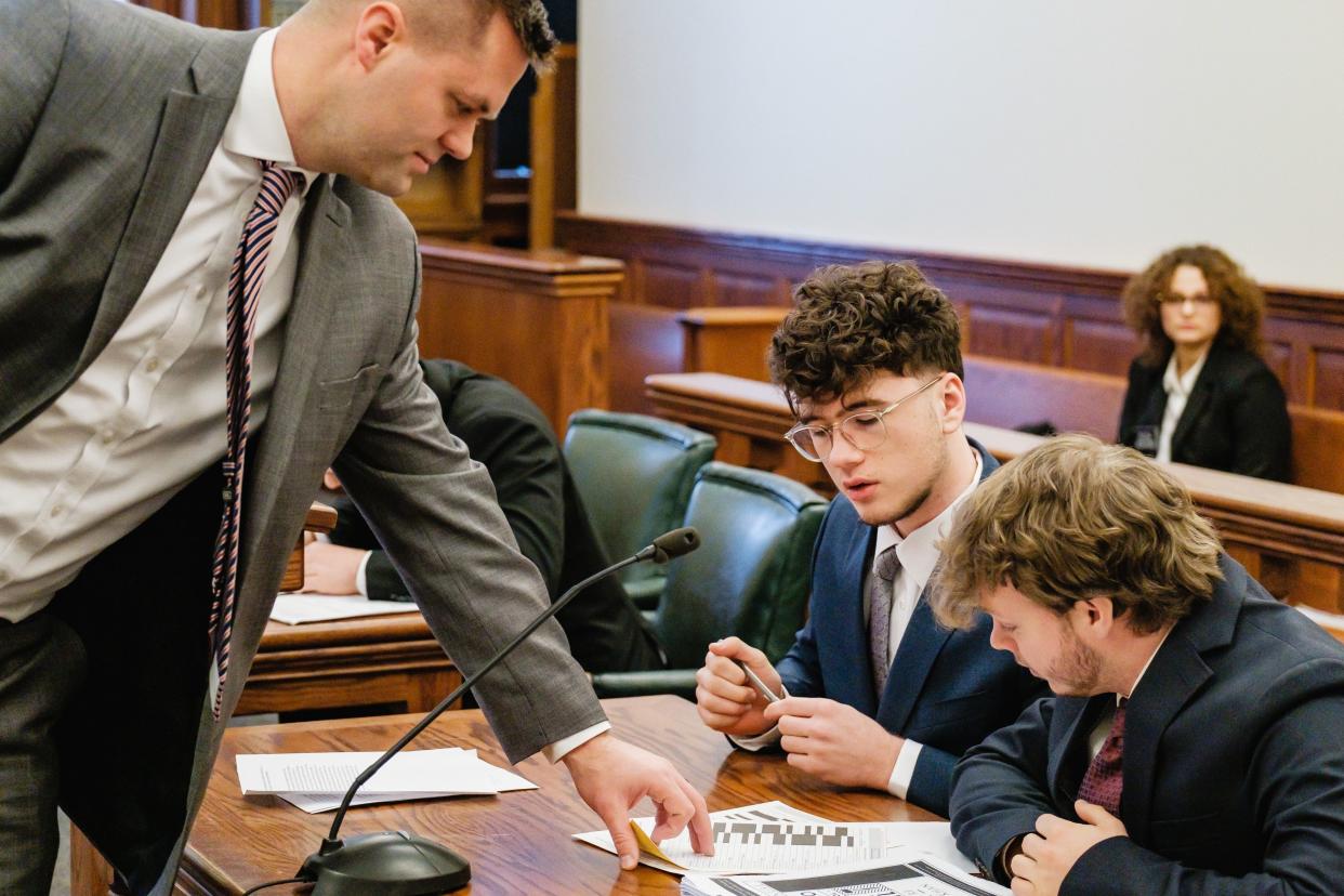 State Rep. Brett Hillyer (R-Uhrichsville), left, collects score sheets from New Philadelphia High School students Leo Kochera, middle, and his co-counsel, Brad Waugh, during the regional competition of the 40th annual Ohio High School Mock Trial Competition held recently at the Tuscarawas County Courthouse. New Philadelphia competed against Steubenville in Judge Elizabeth Lehigh Thomakos' courtroom, while other area schools competed in other courtrooms.