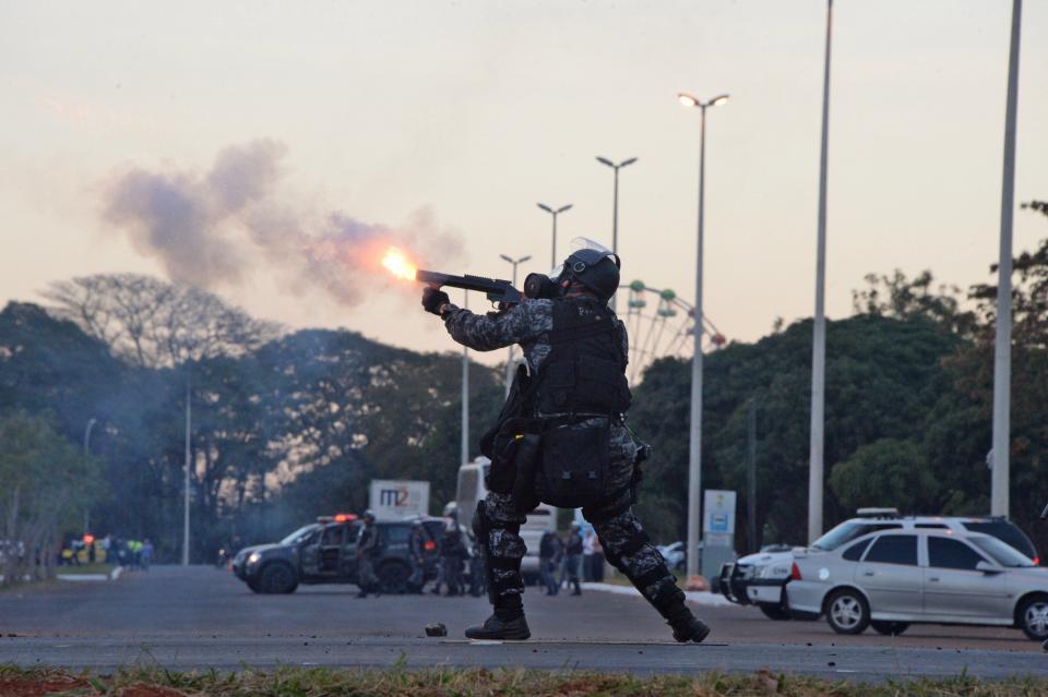 A riot policeman confronts protesters during clashes