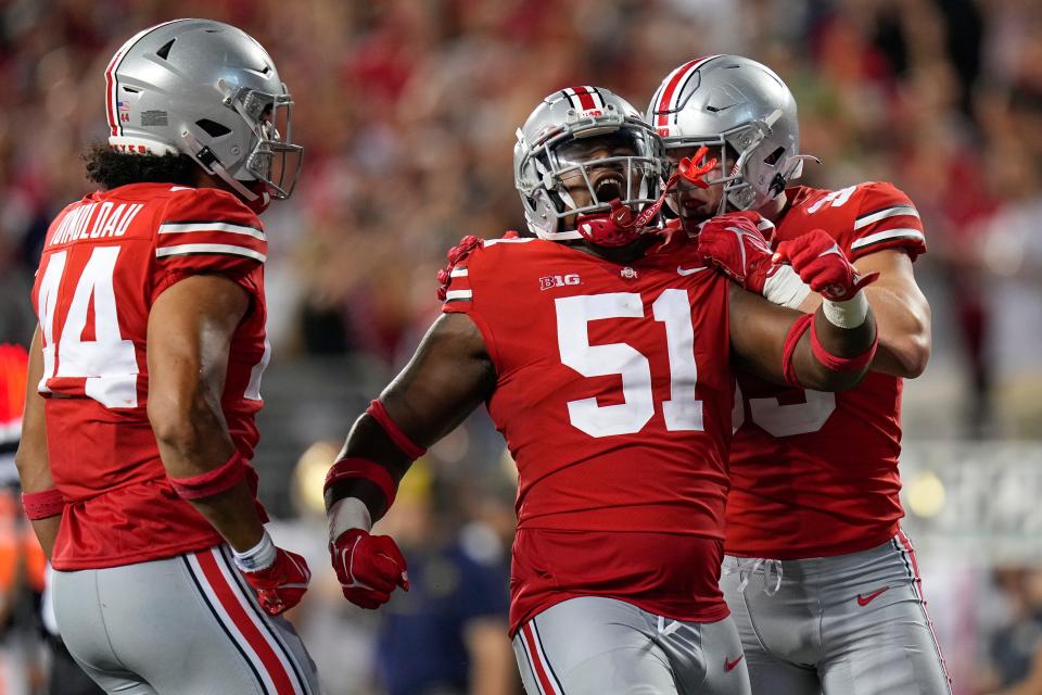 Sep 3, 2022; Columbus, Ohio, USA;  Ohio State Buckeyes defensive end Jack Sawyer (33) and defensive end J.T. Tuimoloau (44) celebrate after a sack by defensive tackle Michael Hall Jr. (51) against the Notre Dame Fighting Irish during the fourth quarter at Ohio Stadium. Ohio State won 21-10.  Mandatory Credit: Adam Cairns-USA TODAY Sports